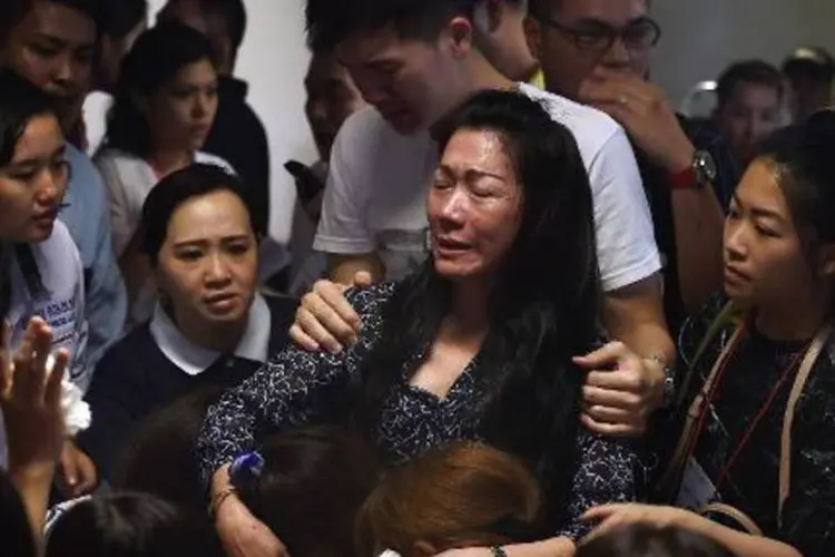 Famílias de passageiros do voo AirAsia, choram após a descoberta dos destroços da aeronave (Manan Vatsyayana/AFP)