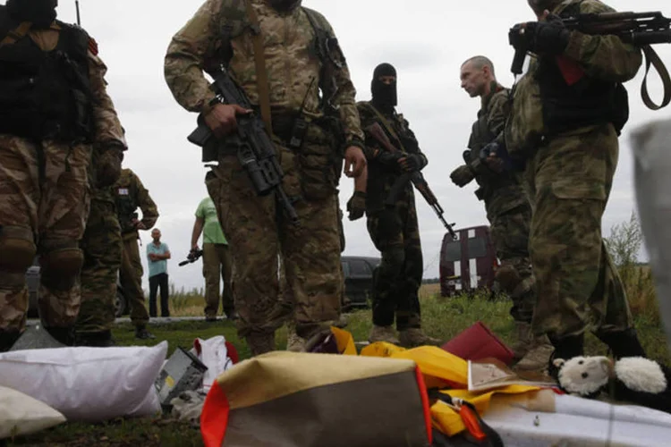 
	Separatistas pr&oacute;-R&uacute;ssia olham pertences das v&iacute;timas do acidente a&eacute;reo da Malaysia Airlines
 (Maxim Zmeyev/Reuters)