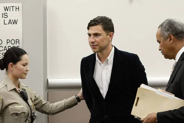 Vitalii Sediuk, acusado de agredir Brad Pitt, pe escoltado por uma policial em Los Angeles, nos EUA (Kevork Djansezian/Reuters)