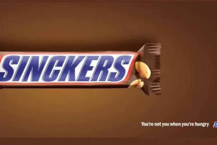 Anúncio do Snickers com a grafia errada: painel mostra o famoso chocolate, mas na embalagem, ao invés de Snickers, a grafia está propositadamente incorreta - “Sinckers” (.)