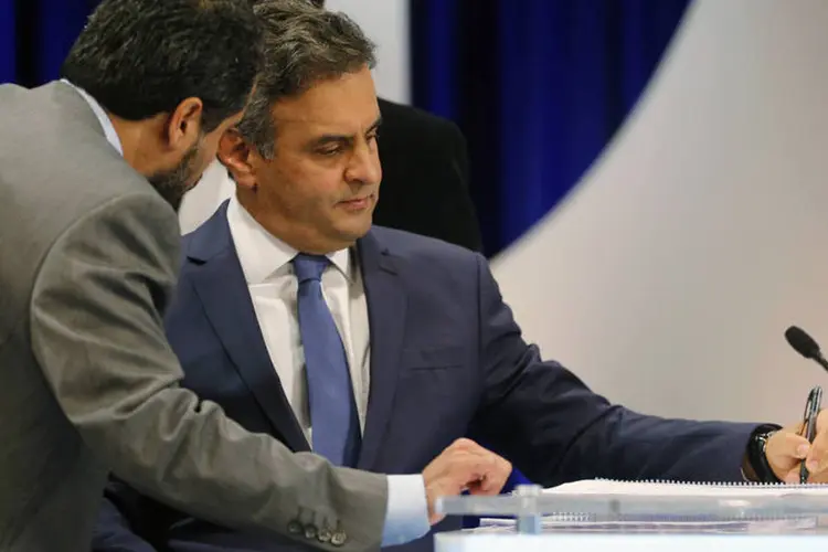 Aécio Neves (PSDB) conversa com assessor durante intervalo do debate organizado pelo SBT, em São Paulo (Paulo Whitaker/Reuters)