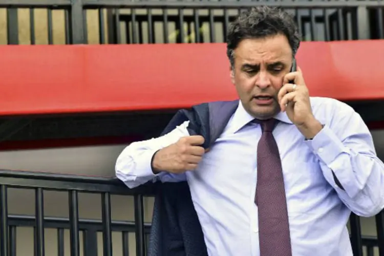 Senador Aécio Neves (PSDB-MG) conversa no celular em Caracas, dia 18/06/2015 (Carlos Becerra / AFP)