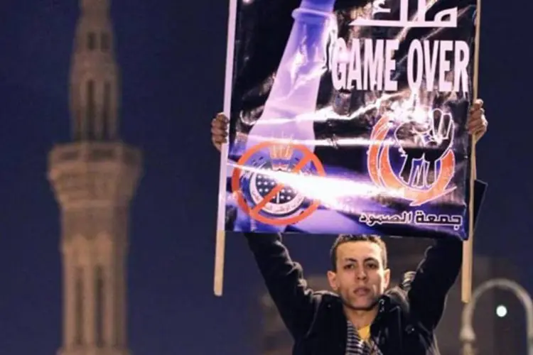 Manifestante na praça Tahrir exibe placa com os dizeres "game over", ou "fim de jogo" (Getty Images)