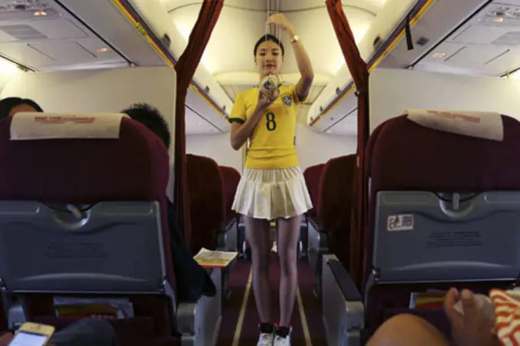 Aeromoça vestida com camisa do Brasil, na China (Wong Campion / Reuters)