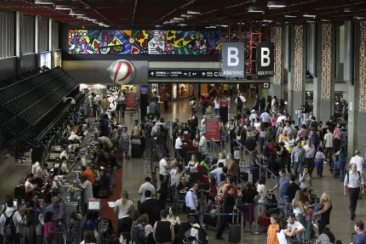 
	Passageiros no aeroporto de Guarulhos, em S&atilde;o Paulo: quase um ter&ccedil;o do movimento foi concentrado em tr&ecirc;s aeroportos concedidos &agrave; iniciativa privada
 (Dado Galdieri/Bloomberg)