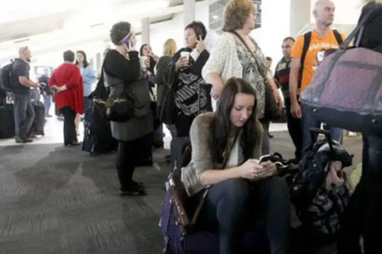 Uma longa fila de passageiros se forma em um dos terminais do aeroporto de Perth:  transporte aéreo da Oceania está afetado há quatro dias (Tony Ashby/AFP)