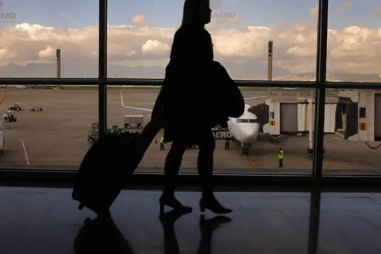 
	Passageira caminha com mala no aeroporto do Gale&atilde;o: aeronautas pleiteiam reajuste salarial de 8%
 (David Silverman/Getty Images)