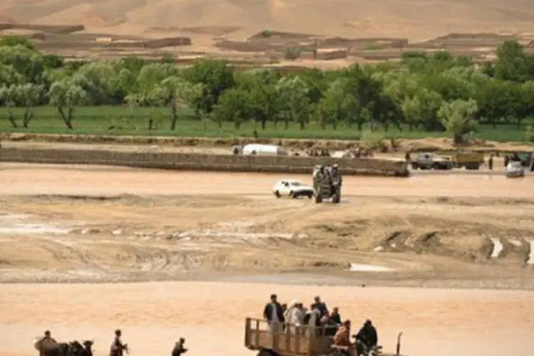 
	Afeg&atilde;os cruzam rio de trator perto do Camp Phoenix, onde soldados americanos est&atilde;o baseados: o governo atribuiu o ataque aos talib&atilde;s (Peter Parks/AFP)