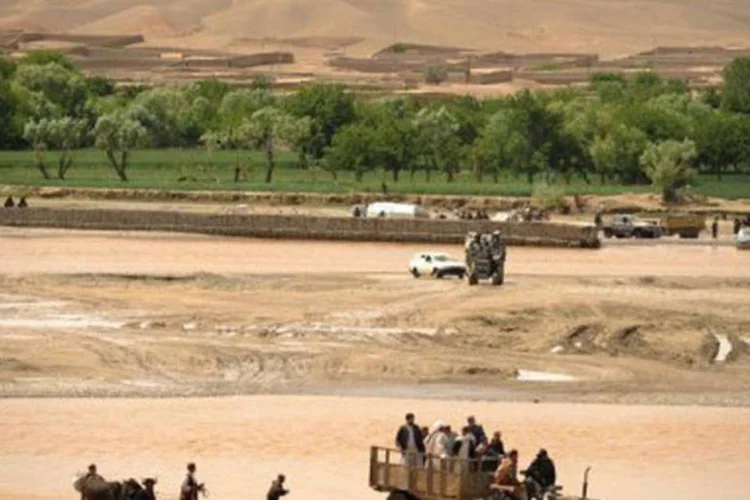 
	Pessoas cruzam rio perto da cidade de Musa Qala, na prov&iacute;ncia afeg&atilde; de Helmand, onde aconteceria o casamento
 (Peter Parks/AFP/AFP)