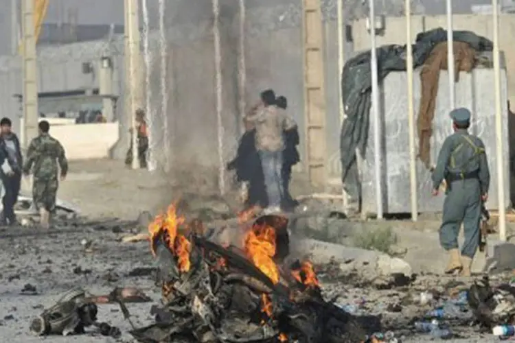 
	Policiais afeg&atilde;os observam a &aacute;rea do ataque suicida em Cabul: a maioria das v&iacute;timas estrangeiras era de sul-africanos que trabalhavam para uma empresa de avia&ccedil;&atilde;o
 (Massoud Hossaini/AFP)