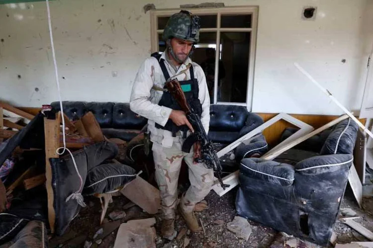 
	Militar afeg&atilde;o inspecionando pr&eacute;dio danificado ap&oacute;s explos&atilde;o no consulado paquistan&ecirc;s, em Jalalabad
 (REUTERS/ Parwiz)