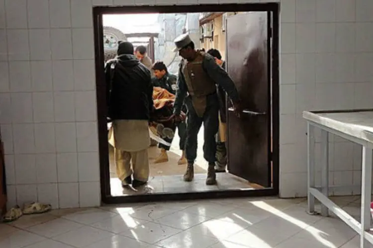 Policiais afegãos carregam corpo de civil em necrotérop após ataque suicida em Khost (©afp.com / Mohammad Rasool Adil)