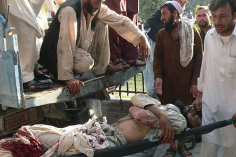 
	Afeg&atilde;os carregam um homem ferido em um atentado suicida para o hospital em Jalalabad: o alvo do ataque era o governador do distrito de Dur Baba
 (Noorullah Shirzada/AFP)