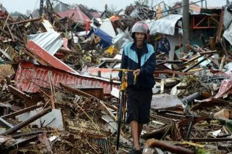 Homem caminha em meio a destroços em Tacloban, na ilha de Leyte, nas Filipinas (AFP/Noel Celis)