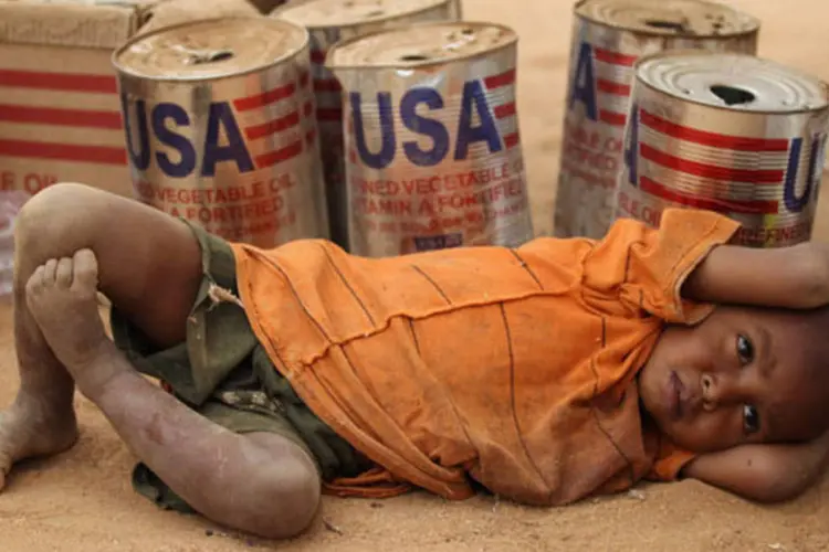 Criança descansa ao lado de latas de óleo vazias em campo de refugiados: seria necessário levar 400 toneladas de alimentos por semana por avião, segundo a Unicef (Oli Scarff/Getty Images)