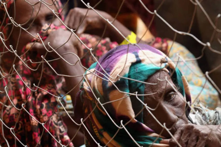 Duas mulheres aguardam para receber alimento no campo de  Dadaab, considerado o maior do mundo, com mais de 180 mil pessoas (Oli Scarff/Getty Images)