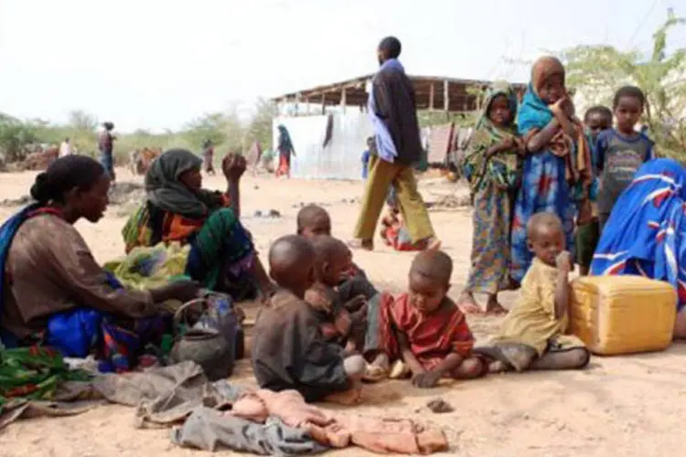 Mulheres aguardam ao lado dos filhos por ajuda e comida em um campo de refugiados somali: a taxa de desnutrição aguda se situa em 50% na Somália (Judith Schuler/AFP)