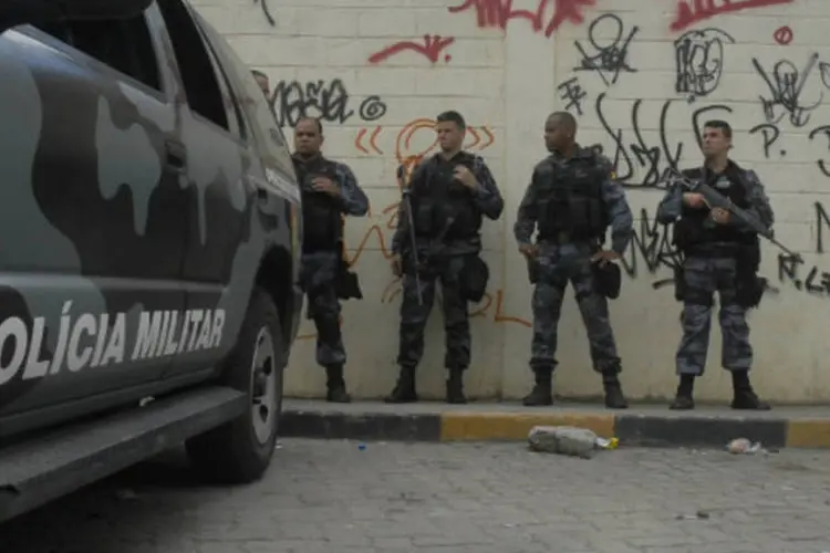 
	Policiais da UPPs em comunidade carioca: ele teria tentado sair do carro para reagir, mas foi baleado
 (Tânia Rêgo/ABr)