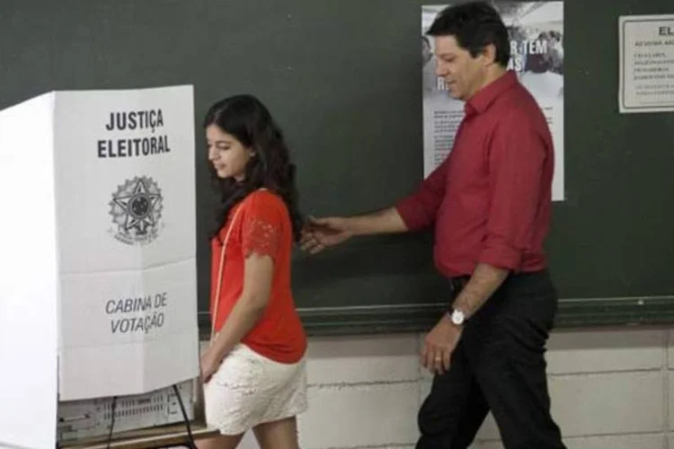 O candidato à prefeitura pelo PT, Fernando Haddad, vota junto de sua filha Carolina no segundo turno das eleições municipais de 2012 (Agência Brasil)