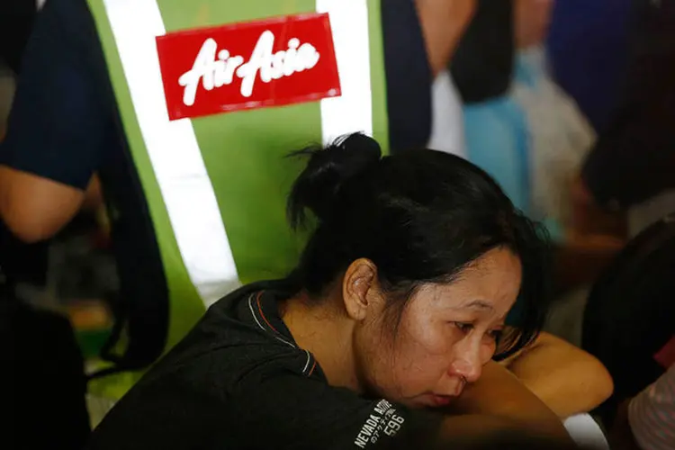 Parente de passageiro a bordo do voo QZ8501 desaparecido da AirAsia espera notícias no aeroporto   ( REUTERS/Beawiharta)