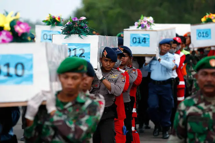 Caixões com corpos de vítimas de acidente da AirAsia, que serão transportadas em avião militar no aeroporto em Pangkalan Bun (REUTERS/Darren Whiteside)