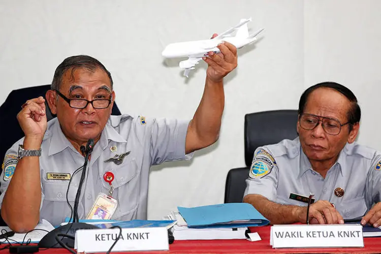 Tatang Kurniadi (e), chefe do Comitê de Segurança Nacional do Transporte da Indonésia, segura um aeromodelo de avião para explicar acidente da AirAsia   (REUTERS/Darren Whiteside)