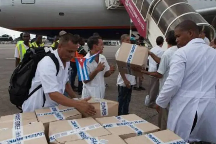 
	Primeiros integrantes de um contingente de 165 funcion&aacute;rios da &aacute;rea de sa&uacute;de cubanos desembarcam material m&eacute;dico em Serra Leoa
 (Florian Plaucheur/AFP)