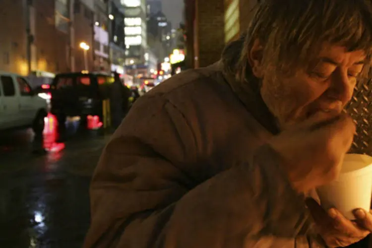 Morador de rua come uma sopa após distribuição de voluntários em um centro comunitário de Manhattan, em Nova York (Chris McGrath/Getty Images)