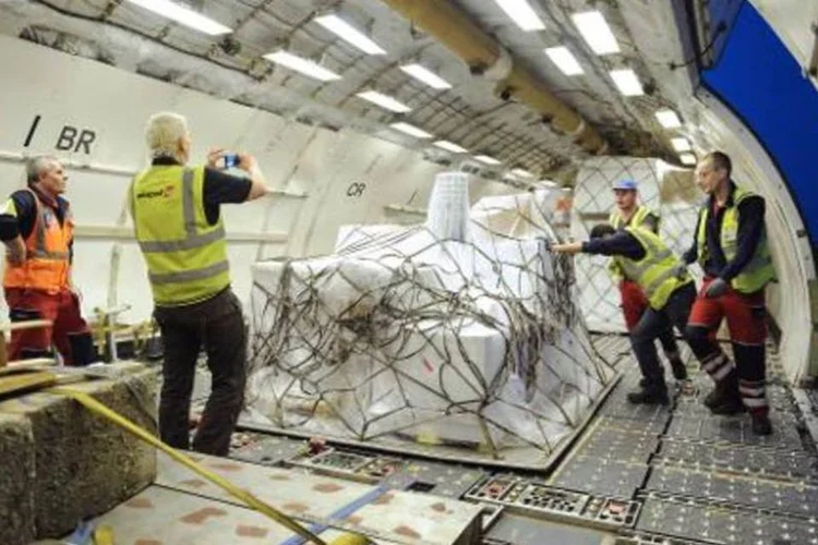Pessoas organizam ajuda humanitária do Comitê Internacional da Cruz Vermelha em uma avião para ser enviada ao Iêmen (Sophie Kip/AFP)