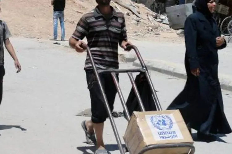 Morador de campo de refugiados em Damasco recebe ajuda humanitária da ONU (Rani Al-Sayed/AFP)