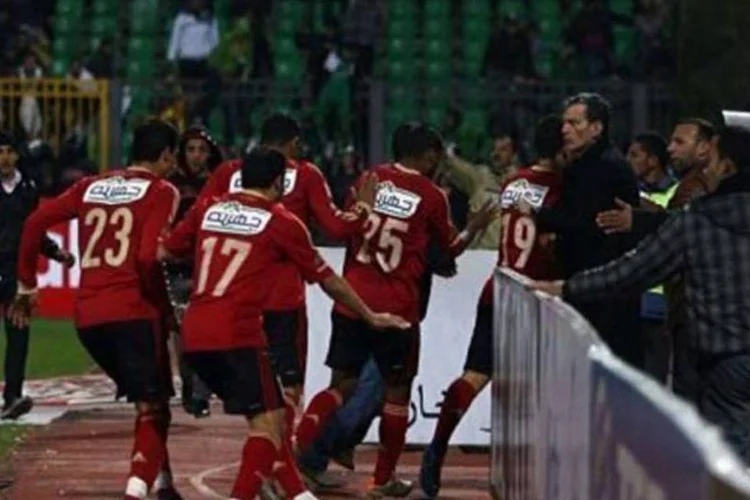 Jogadores do Al-Ahly deixam o campo após a torcida adversária invadir o local (AFP)