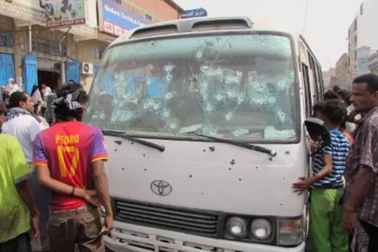 Al Qaeda: Moradores observam ônibus, alvejado por atirador enquanto carregava funcionários de um hospital militar, em Adem, no Iêmen (AFP/Arquivos)