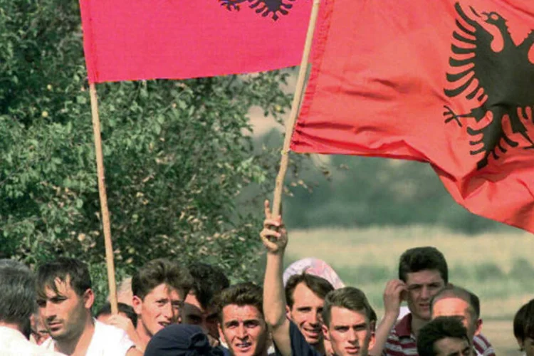 
	Manifestantes seguram bandeiras da Alb&acirc;nia: neste domingo, os eleitores foram &agrave;s urnas para escolher 140 deputados, entre 6,9 mil candidatos de 66 partidos pol&iacute;ticos
 (Wikimedia Commons)
