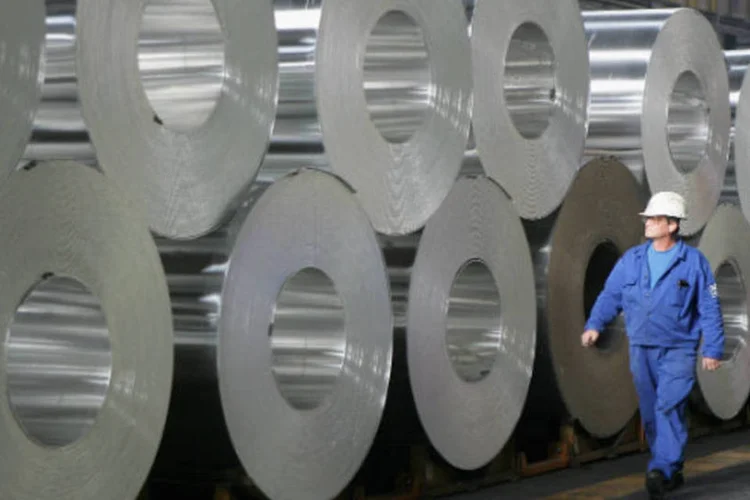Funcionário caminha entre rolas de alumínio em uma fábrica da Alcoa em Szekesefehervar, na Hungria (Sean Gallup/Getty Images)
