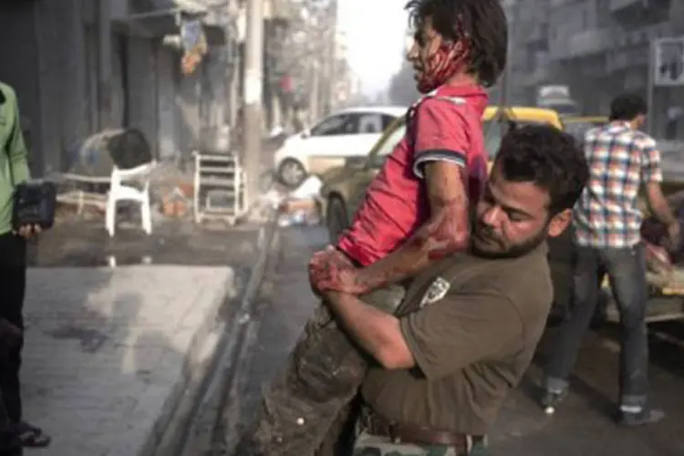 Rebelde ajuda companheiro ferido na localidade de Arqub, em Alepo
 (Zac Baillie/AFP)