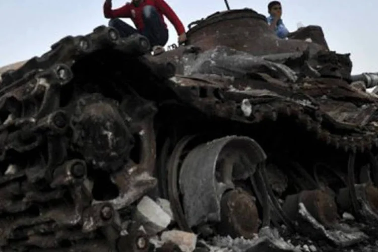 
	Crian&ccedil;as brincam nos destro&ccedil;os de um tanque em Alepo, na S&iacute;ria: dois civis morreram nos bombardeios contra focos da resist&ecirc;ncia em Alepo
 (Tauseef Mustafa/AFP)