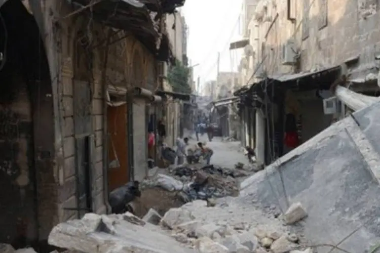 Sírios caminham em meio a construções destruídas em Alepo em 23 de outubro
 (Philippe Desmazes/AFP)
