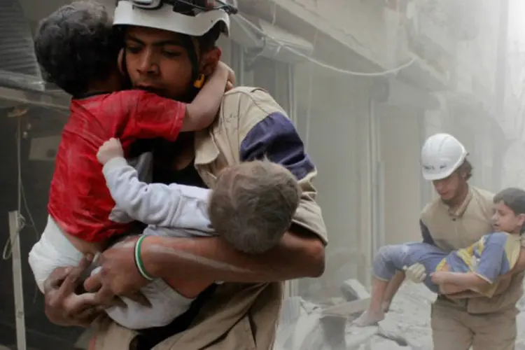 Voluntários resgatam crianças após bombardeio em Aleppo: segunda maior cidade síria tem regiões que não recebem ajuda humanitária desde julho (Reuters)