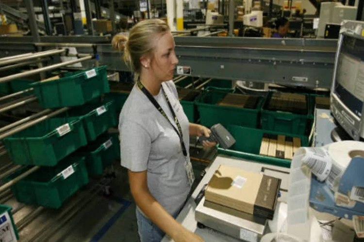 
	Mulher registra um dos produtos vendidos pela Amazon no centro de log&iacute;stica da empresa
 (GettyImages)