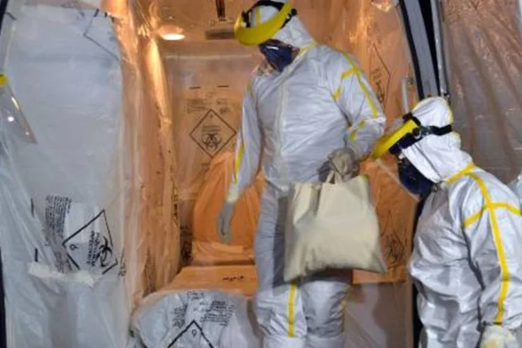 Ambulância é preparada por equipe de saúde para transportar suposto paciente com ebola (Luiz Carlos Cruz/AFP)
