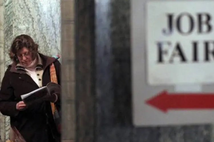 
	Americana observa panfletos na fila de uma feira de empregos em S&atilde;o Francisco: os analistas previam uma alta mais forte nos pedidos de seguro-desemprego
 (Justin Sullivan/Getty Images/AFP)