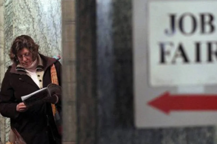 Americana observa panfletos na fila de uma feira de empregos em São Francisco (Justin Sullivan/Getty Images/AFP)