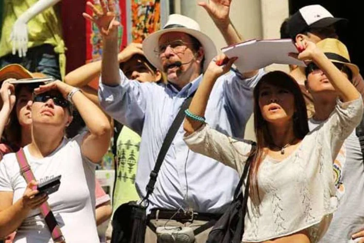Um grupo de turistas observa um prédio na Broadway, sob sol escaldante, em Nova York
 (Getty Images)