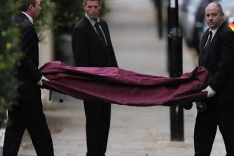 Policiais retiram o corpo de Amy Winehouse de sua casa, em Londres (Carl Court/AFP)