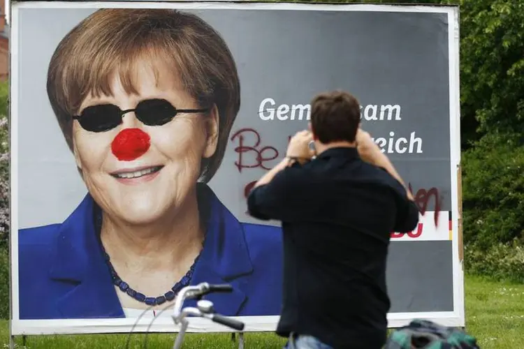 Cartaz para as eleições europeias com a imagem de Angela Merkel é visto vandalizado em Berlim, na Alemanha (Thomas Peter/Reuters)