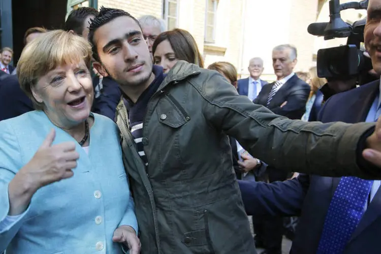
	Angela Merkel tira foto com refugiado: &quot;este &eacute; um momento em que a Europa tem pela frente de novo um grande desafio, uma prova de dimens&otilde;es hist&oacute;ricas&quot;
 (Reuters / Fabrizio Bensch)