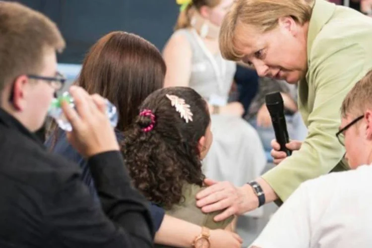
	A chanceler alem&atilde;, Angela Merkel, conversa com menina refugiada palestina durante programa de televis&atilde;o
 (Steffen Kugler/AFP)