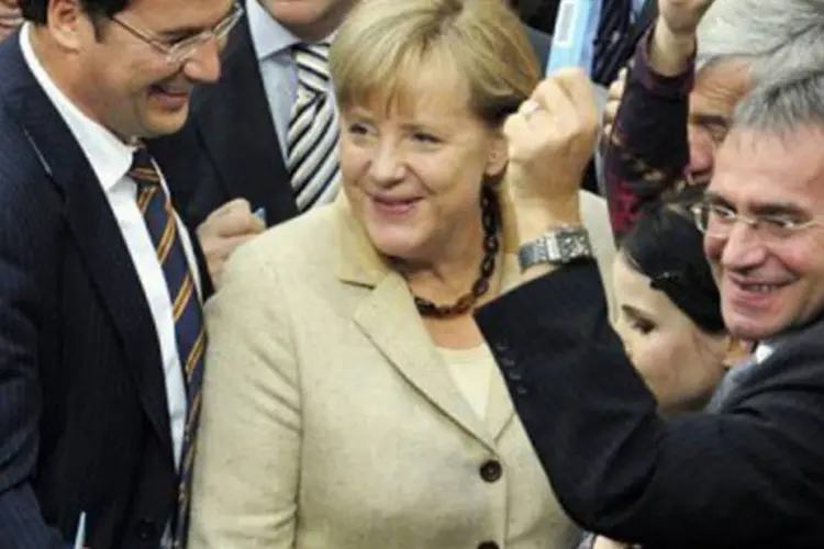 Angela Merkel em meio a parlamentares comemora a aprovação da ampliação do fundo
 (John Macdougall/AFP)