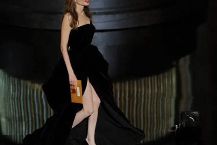 Jolie, de 36 anos e muito magra, apareceu no tapete vermelho vestindo um vestido preto Versace, elaborado em veludo e com uma profunda abertura à direita (Photo by Kevin Winter/Getty Images)