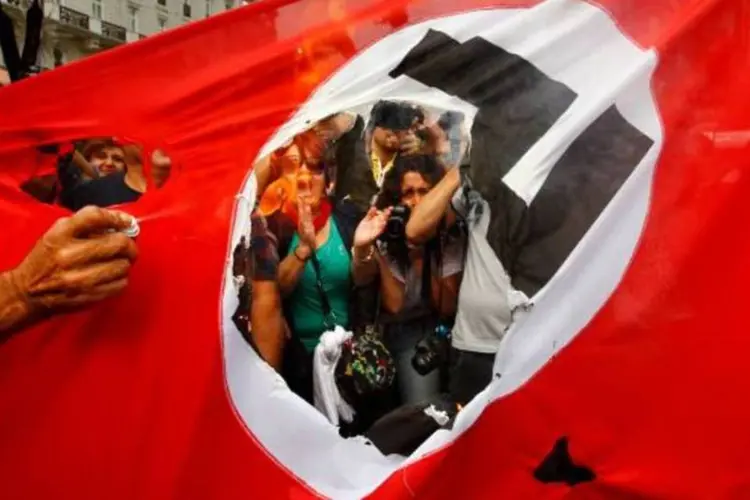 
	Bandeira nazista foi incendiada durante os protestos anti-merkel na Europa
 (Yannis Behrakis/Reuters)